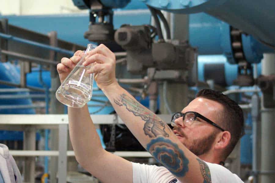 Man holding a beaker with purified water