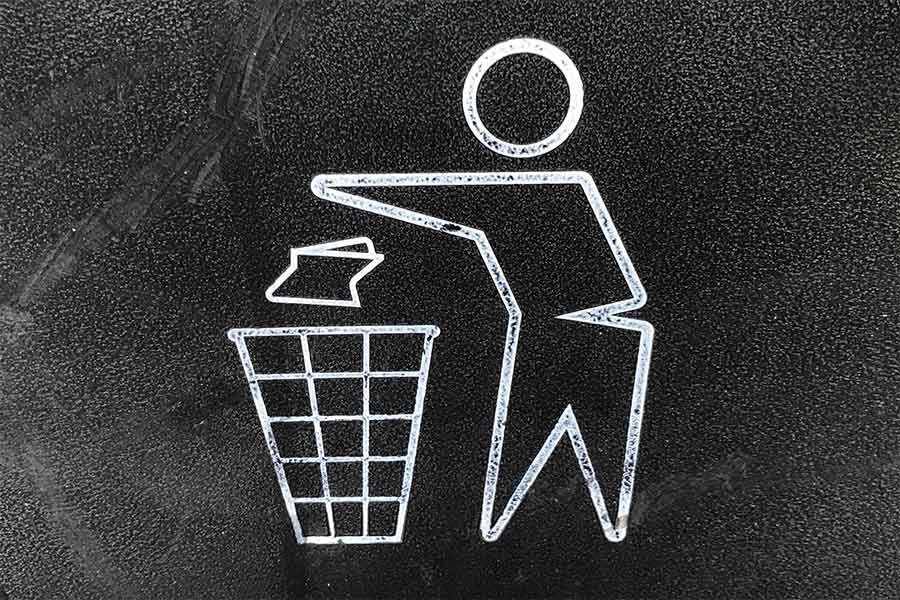 Signage of a person dropping trash into a waste basket