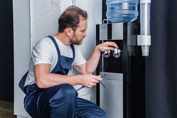 Man cleaning and maintaining a water cooler