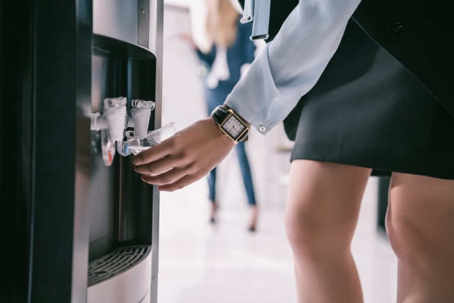 A woman getting purified water from a water cooler at a business office in Austin, TX.