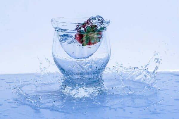 strawberry dropping into cold glass of water