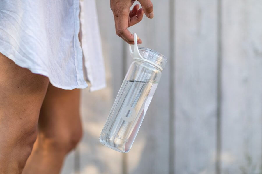 A person carrying a reusable bottle to enjoy clean water thanks to water filtration in Austin.