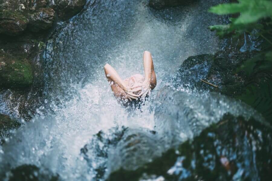a person bathing in a waterfall viewed from above