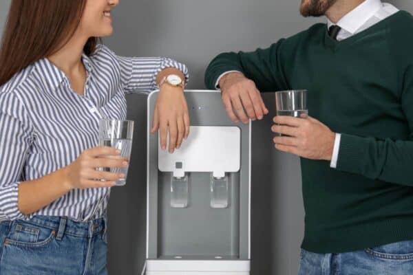 co-workers chatting and laughing at the office water cooler