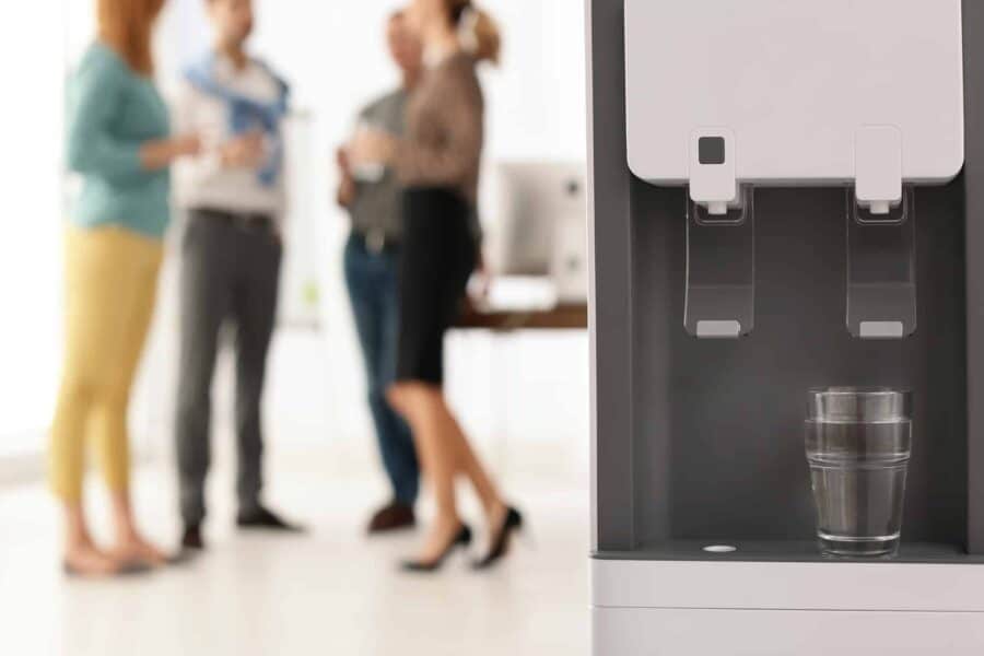 employees gathered on the background at the office bottleless water cooler