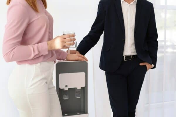An image of happy workers enjoying a glass of clear water with botteless water cooler