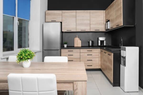 Cozy modern kitchen interior with new furniture and bottleless water cooler.